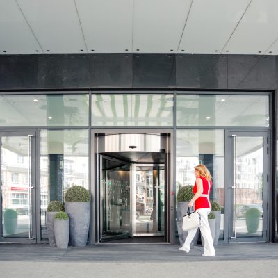 Beautiful woman, female entrepreneur goes to the entrance to the business center. Horizontal photo